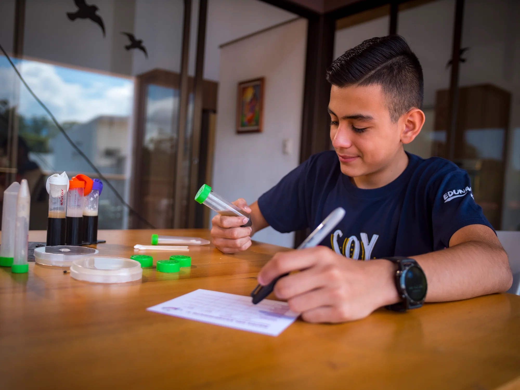 Edunámica beneficiary filling out his science experiment record sheet