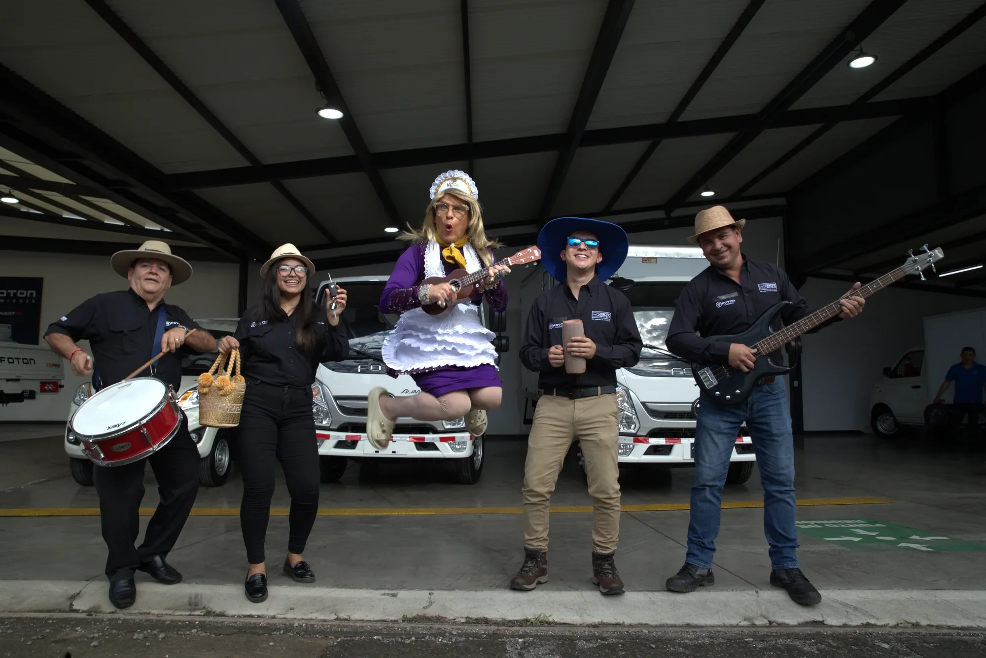 Doña Merry jumps with a ukulele in front of Foton Aumark trucks, alongside the Pacific Motors team