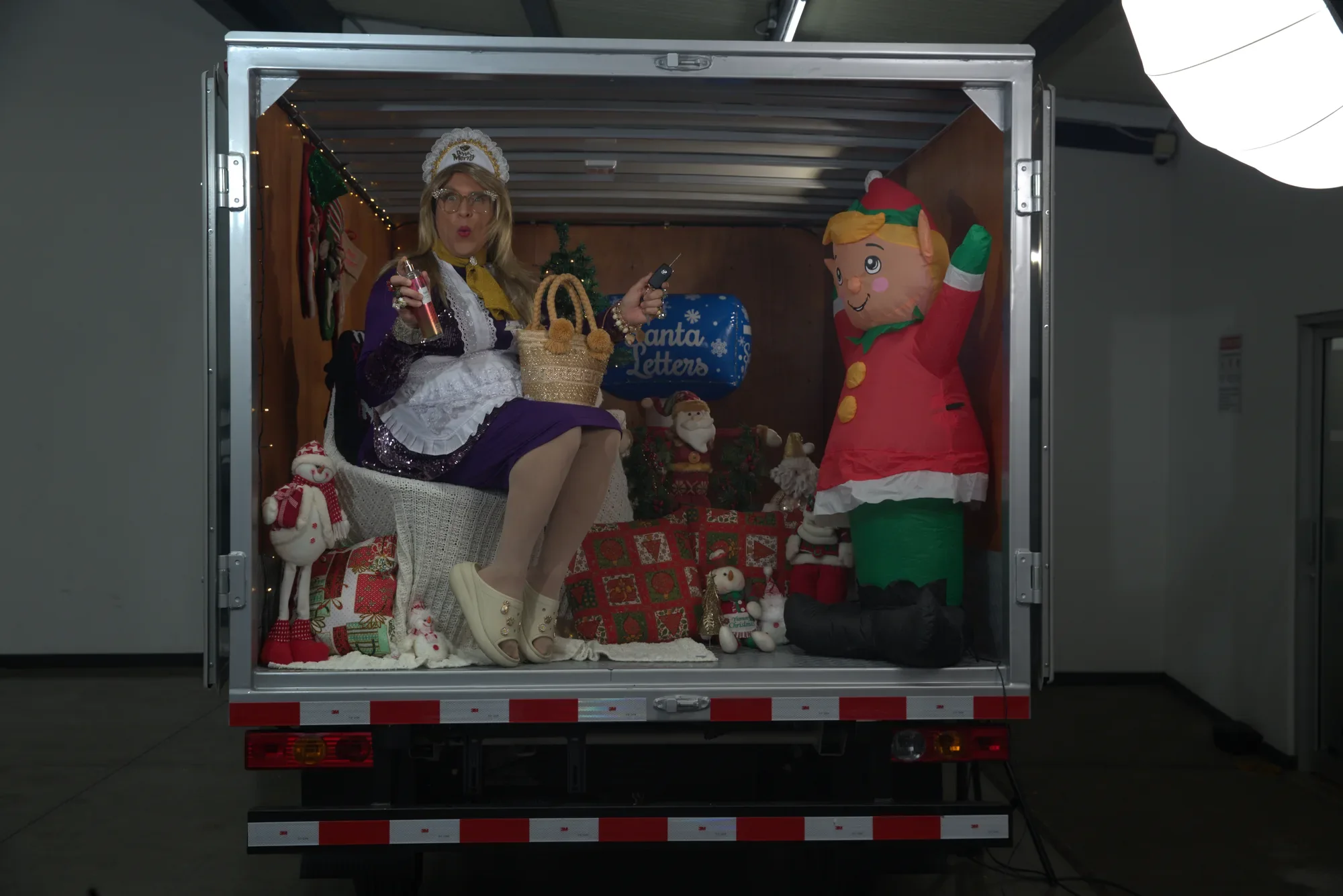 Doña Merry sitting inside a Foton cargo box decorated for Christmas